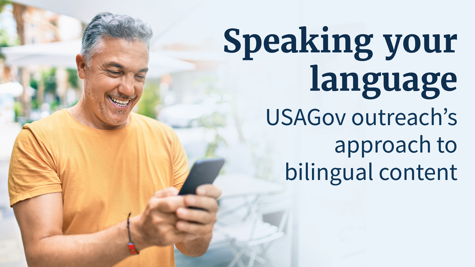 Person on smiling look at phone. Text: Speaking your language: USAGov outreach’s approach to bilingual content